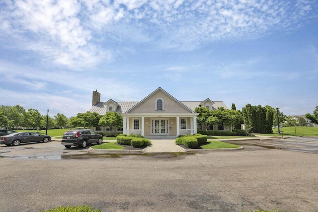 5985 Mcjessy Dr, Westerville, OH 43081 - view of front of house with french doors, a chimney, a metal roof, and a standing seam roof