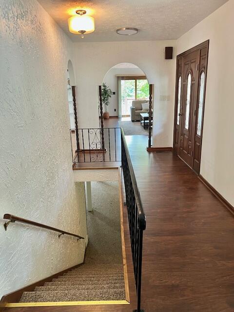 171 Ginder Rd NE, Lancaster, OH 43130 - entrance foyer featuring arched walkways, wood finished floors, a textured wall, a textured ceiling, and stairs