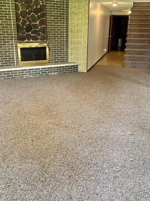 171 Ginder Rd NE, Lancaster, OH 43130 - unfurnished living room featuring stairway, carpet floors, and a glass covered fireplace