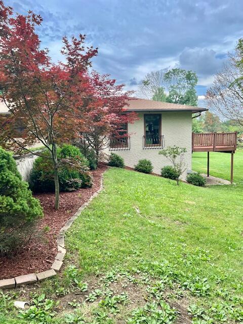 171 Ginder Rd NE, Lancaster, OH 43130 - view of property exterior featuring a deck, a yard, and stucco siding