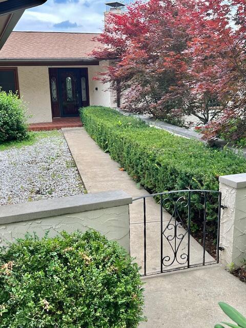 171 Ginder Rd NE, Lancaster, OH 43130 - view of exterior entry with stucco siding, a gate, a porch, and a chimney