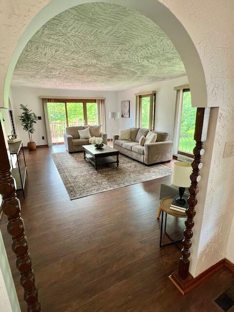 171 Ginder Rd NE, Lancaster, OH 43130 - living room with arched walkways, wood finished floors, healthy amount of natural light, a textured wall, and a textured ceiling