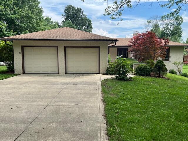 171 Ginder Rd NE, Lancaster, OH 43130 - view of front of house featuring stucco siding, a front lawn, concrete driveway, and a garage