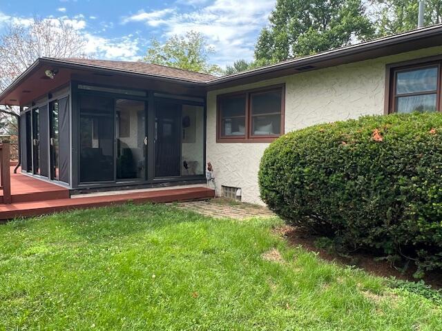 171 Ginder Rd NE, Lancaster, OH 43130 - rear view of house with a sunroom, stucco siding, a yard, and a deck