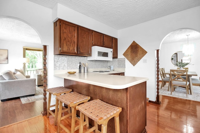 171 Ginder Rd NE, Lancaster, OH 43130 - kitchen with white appliances, arched walkways, wood-type flooring, light countertops, and a textured ceiling
