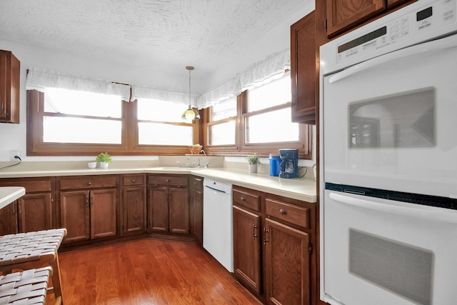171 Ginder Rd NE, Lancaster, OH 43130 - kitchen with white appliances, wood finished floors, light countertops, decorative light fixtures, and a textured ceiling