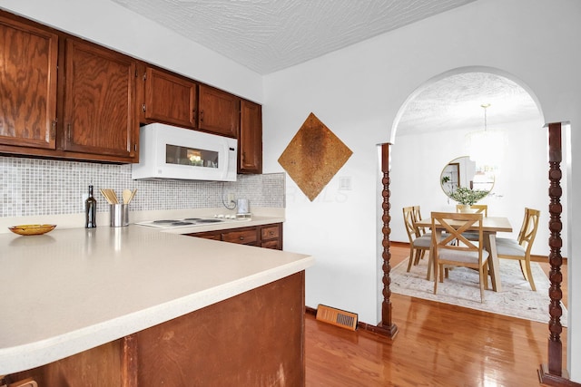 171 Ginder Rd NE, Lancaster, OH 43130 - kitchen featuring white appliances, wood finished floors, light countertops, tasteful backsplash, and a textured ceiling