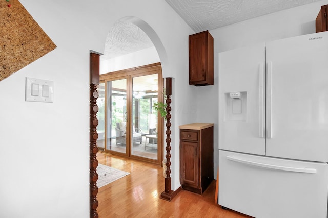 171 Ginder Rd NE, Lancaster, OH 43130 - kitchen with white refrigerator with ice dispenser, arched walkways, light wood-style flooring, a textured ceiling, and light countertops