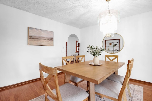 171 Ginder Rd NE, Lancaster, OH 43130 - dining room featuring arched walkways, wood finished floors, a chandelier, and a textured ceiling