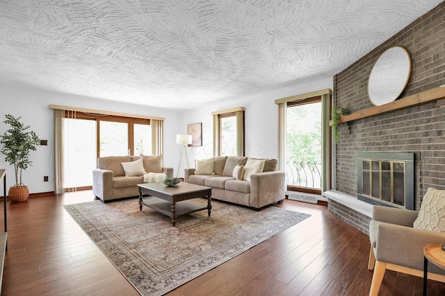 171 Ginder Rd NE, Lancaster, OH 43130 - living room with healthy amount of natural light, a brick fireplace, wood-type flooring, and a textured ceiling
