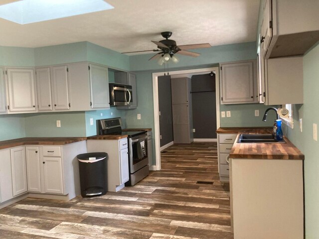 4173 Navajo Trl, Jamestown, OH 45335 - kitchen with stainless steel appliances, dark wood-style flooring, ceiling fan, and a skylight