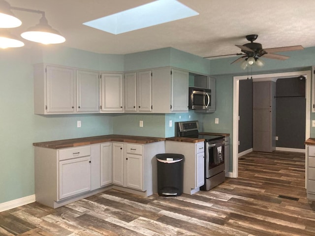 4173 Navajo Trl, Jamestown, OH 45335 - kitchen with stainless steel appliances, dark wood-style flooring, a skylight, white cabinetry, and ceiling fan