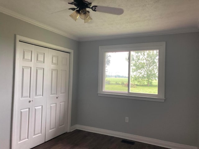 4173 Navajo Trl, Jamestown, OH 45335 - unfurnished bedroom featuring ornamental molding, a closet, dark wood finished floors, and ceiling fan