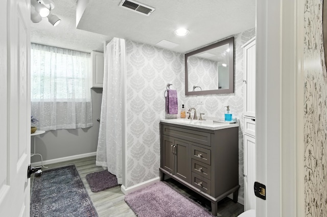 2190 Lendale Dr, Lancaster, OH 43130 - bathroom featuring wallpapered walls, vanity, wood finished floors, and a textured ceiling