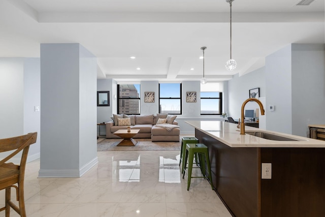 50 W Broad St Unit 3401, Columbus, OH 43215 - kitchen featuring a kitchen island with sink, light marble finish flooring, decorative light fixtures, and recessed lighting