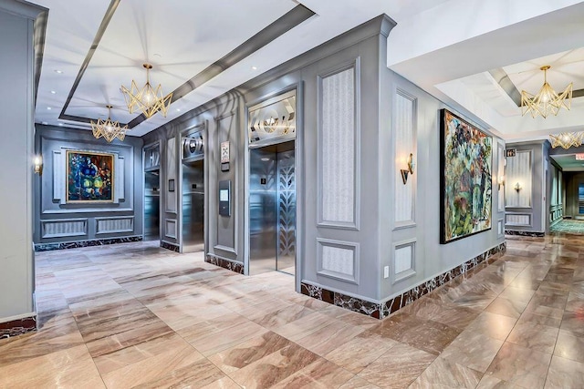 50 W Broad St Unit 3401, Columbus, OH 43215 - hall with a chandelier, elevator, a tray ceiling, and marble finish flooring