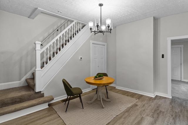 508 E Welch Ave, Columbus, OH 43207 - dining area with stairs, a textured ceiling, wood finished floors, and a chandelier
