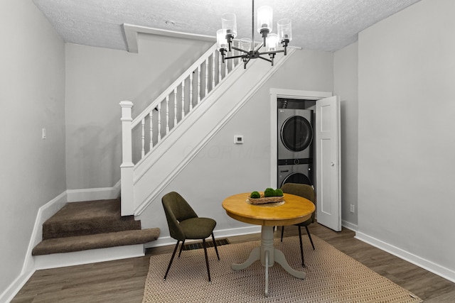 508 E Welch Ave, Columbus, OH 43207 - dining room with estacked washer and dryer, stairs, a textured ceiling, a chandelier, and wood finished floors