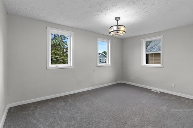 508 E Welch Ave, Columbus, OH 43207 - spare room featuring a textured ceiling and dark carpet