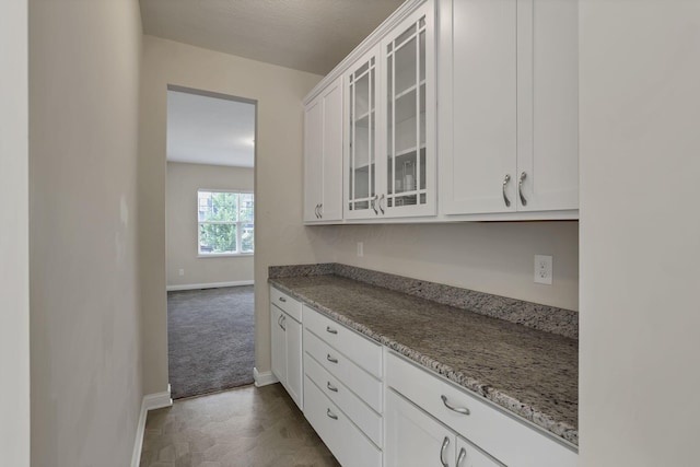 7263 Yarrow Run Rd, Plain City, OH 43064 - kitchen with glass insert cabinets, white cabinetry, and light stone counters
