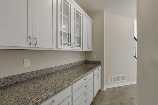 7263 Yarrow Run Rd, Plain City, OH 43064 - kitchen with white cabinets, light stone counters, and glass insert cabinets