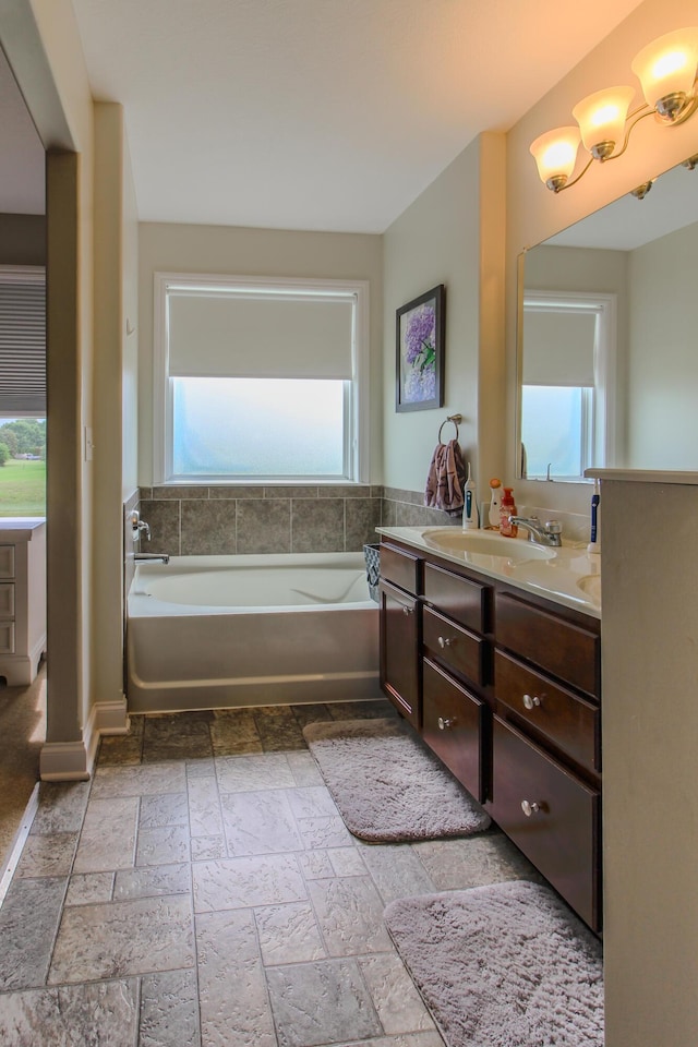 9065 Strawser St, Orient, OH 43146 - bathroom featuring plenty of natural light, vanity, a garden tub, and stone tile flooring