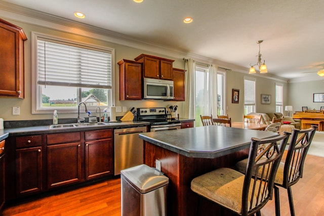 9065 Strawser St, Orient, OH 43146 - kitchen featuring appliances with stainless steel finishes, dark countertops, a breakfast bar, dark wood-style floors, and ornamental molding