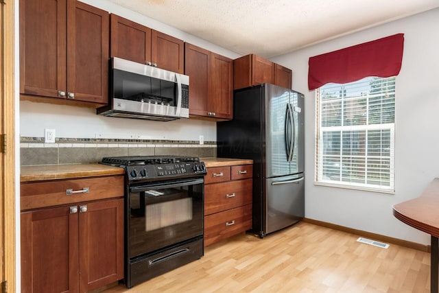 277 Plum Run Ct, Commercial Point, OH 43116 - kitchen with appliances with stainless steel finishes, light wood-style floors, and brown cabinetry