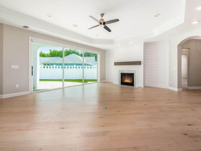 3311 Polden Hill Dr Unit 24, New Albany, OH 43054 - unfurnished living room with a tray ceiling, a ceiling fan, light wood finished floors, ornamental molding, and arched walkways