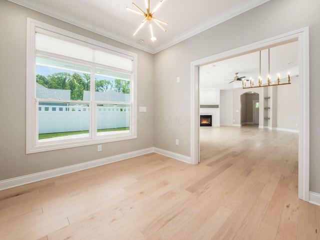 3311 Polden Hill Dr Unit 24, New Albany, OH 43054 - empty room with ornamental molding, light wood-style floors, a lit fireplace, arched walkways, and a chandelier