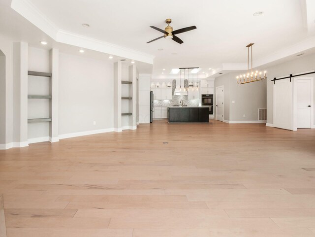 3311 Polden Hill Dr Unit 24, New Albany, OH 43054 - unfurnished living room with a barn door, ceiling fan, crown molding, light wood-style floors, and recessed lighting