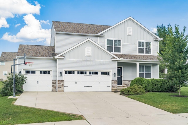 7036 Cannon Dr, Canal Winchester, OH 43110 - view of front of house featuring board and batten siding, concrete driveway, a front yard, an attached garage, and stone siding