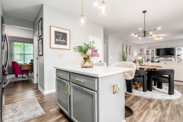 7036 Cannon Dr, Canal Winchester, OH 43110 - kitchen with dark wood-type flooring, a chandelier, light countertops, pendant lighting, and open floor plan