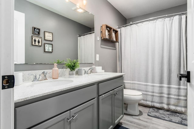 7036 Cannon Dr, Canal Winchester, OH 43110 - bathroom with double vanity, wood finished floors, and a shower with curtain