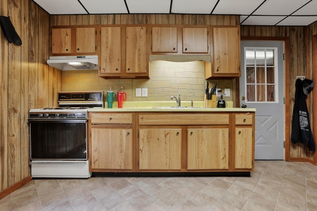 16703 Watkins Rd, Haydenville, OH 43127 - kitchen with under cabinet range hood, white gas range oven, light countertops, wood walls, and decorative backsplash