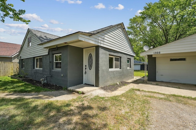 1366 Brown Rd, Columbus, OH 43223 - bungalow with driveway, a garage, a shingled roof, and stucco siding