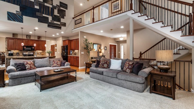 8933 Winding Creek Way, Pickerington, OH 43147 - living area featuring a towering ceiling, stairs, light colored carpet, and recessed lighting