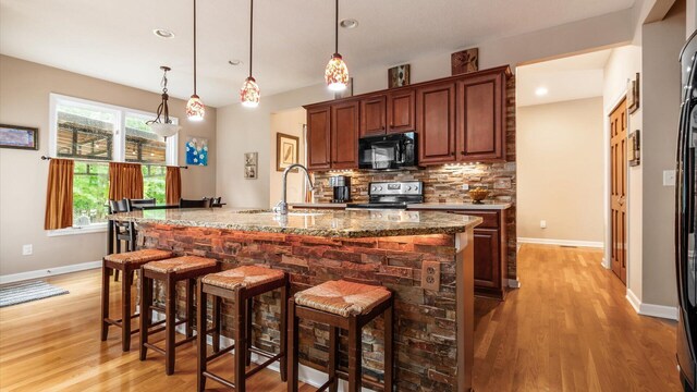 8933 Winding Creek Way, Pickerington, OH 43147 - kitchen with black microwave, stainless steel electric range, light wood-style floors, backsplash, and recessed lighting
