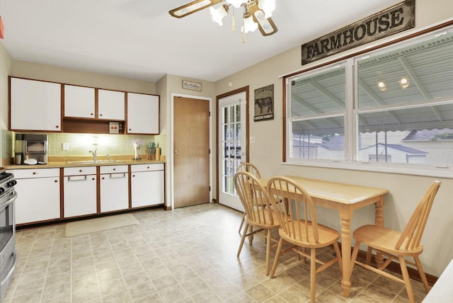 3905 Frazier Rd E, Columbus, OH 43207 - kitchen with dishwasher, white cabinets, backsplash, ceiling fan, and stainless steel range with electric stovetop