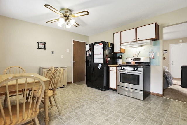 3905 Frazier Rd E, Columbus, OH 43207 - kitchen with stainless steel gas range, under cabinet range hood, black refrigerator with ice dispenser, a ceiling fan, and white cabinets