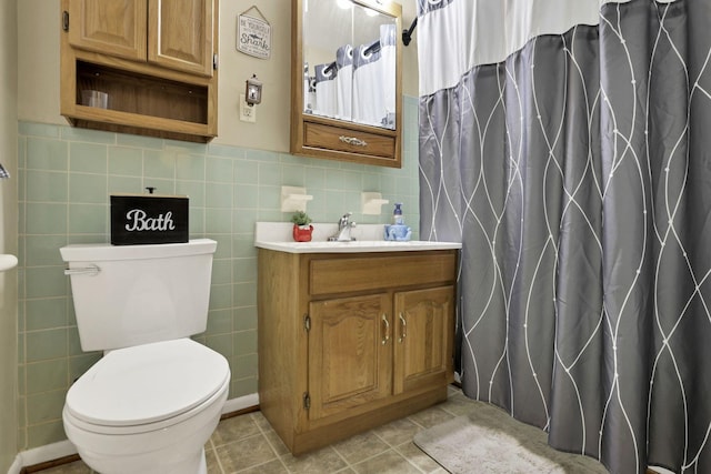 3905 Frazier Rd E, Columbus, OH 43207 - bathroom featuring vanity, curtained shower, tile walls, tile patterned floors, and wainscoting