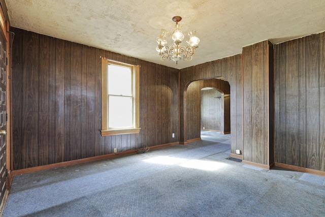 141 W Waterloo St, Canal Winchester, OH 43110 - carpeted spare room featuring arched walkways, a chandelier, and wood walls