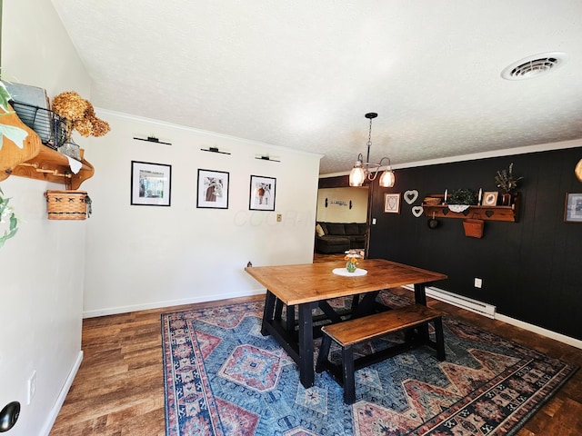 4999 Dickey Rd NE, Bloomingburg, OH 43106 - dining area featuring wood finished floors, ornamental molding, a textured ceiling, and baseboard heating