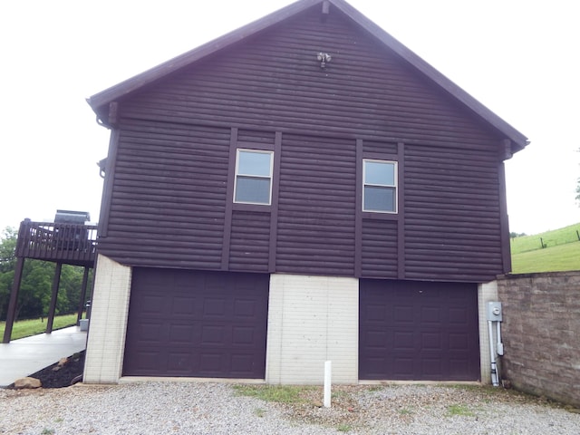 19448 Cr-80, Warsaw, OH 43844 - view of home's exterior featuring brick siding, a garage, and faux log siding