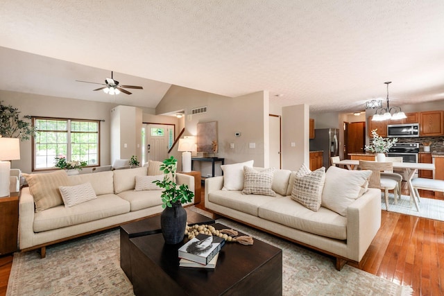 2378 Yagger Bay Dr, Hilliard, OH 43026 - living room with a chandelier, light wood finished floors, ceiling fan, a textured ceiling, and lofted ceiling