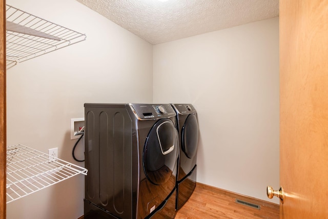 2378 Yagger Bay Dr, Hilliard, OH 43026 - laundry room with washer and clothes dryer, light wood finished floors, and a textured ceiling