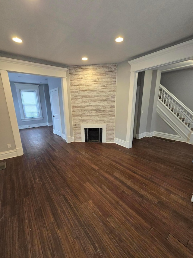 1035 Sullivant Ave, Columbus, OH 43223 - unfurnished living room featuring dark wood-type flooring, stairway, a large fireplace, and recessed lighting