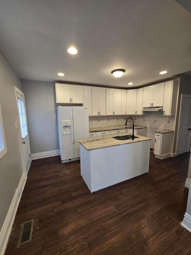 1035 Sullivant Ave, Columbus, OH 43223 - kitchen featuring white refrigerator with ice dispenser, under cabinet range hood, dark wood-style flooring, backsplash, and recessed lighting