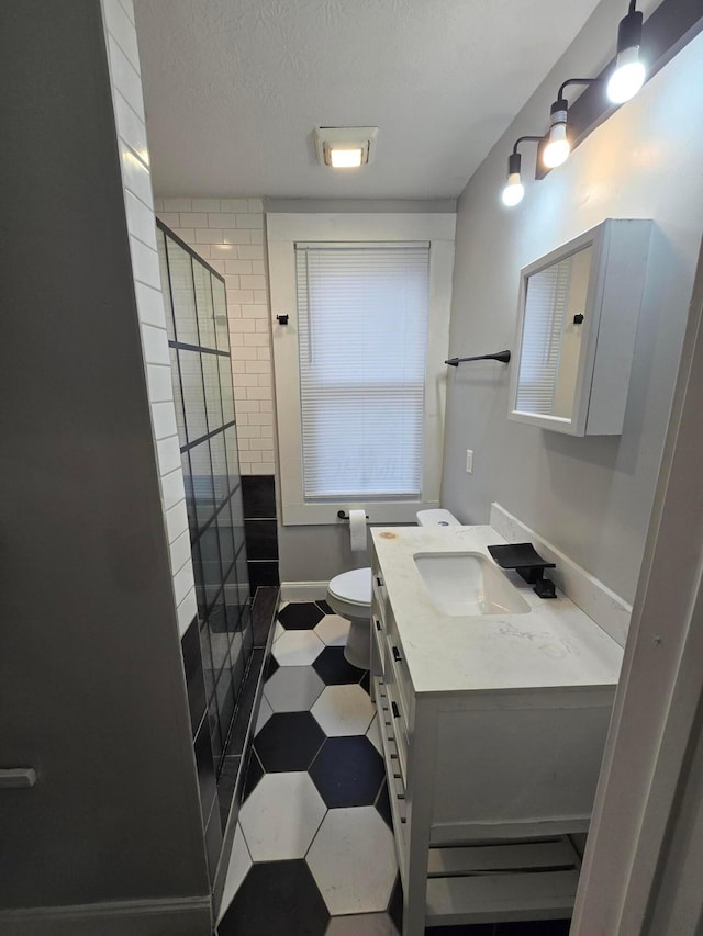 1035 Sullivant Ave, Columbus, OH 43223 - full bathroom featuring vanity, tiled shower, a textured ceiling, and tile patterned floors