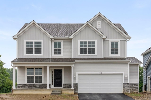4462 Karbarda Way, Hilliard, OH 43026 - craftsman house with covered porch, driveway, an attached garage, roof with shingles, and stone siding